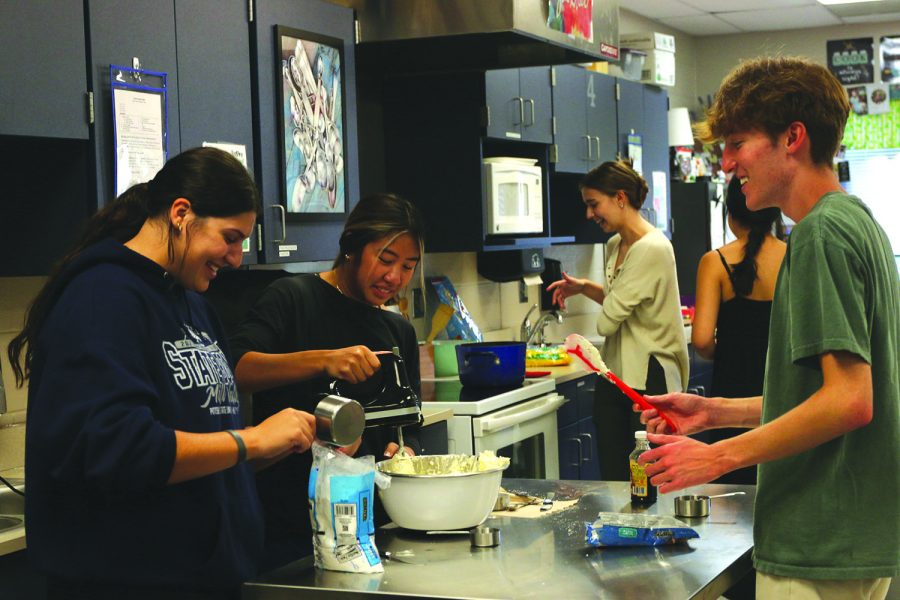 Focused, seniors Amaiya Manirad, Torri Olivarez and Sonny Pentola mix the cookie dough dip.
