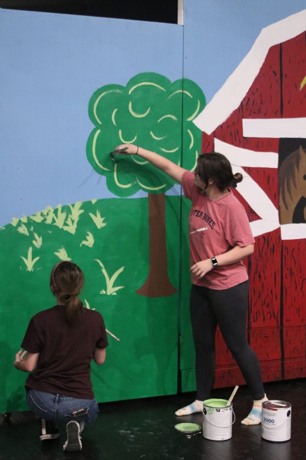 Both adding more detail to the greenery in the background of the set, junior Anna Zwahlen and senior Reece Moulthrop paint together Saturday Oct. 29. 