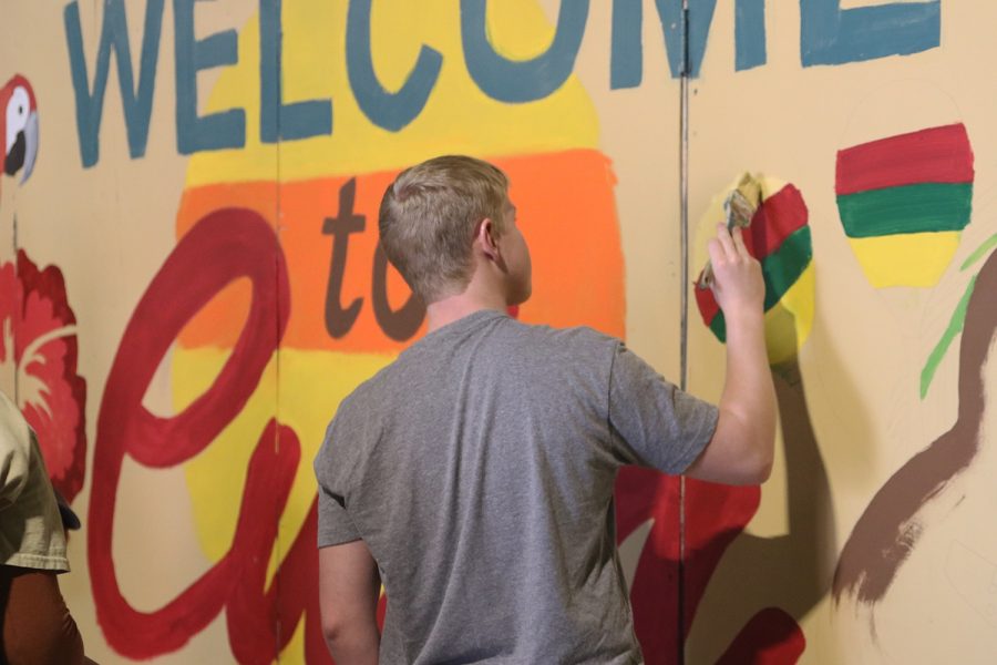 Working on a set, junior Cooper Line adds more color onto a “Welcome to Cuba” sign Saturday, Oct. 29.