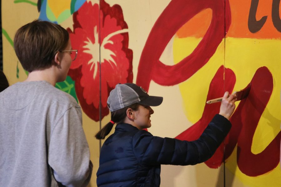 While adding another coat of paint onto the words “Cuba,” junior Grace Cormany instructs a student on what to help out with Saturday, Oct. 29. 