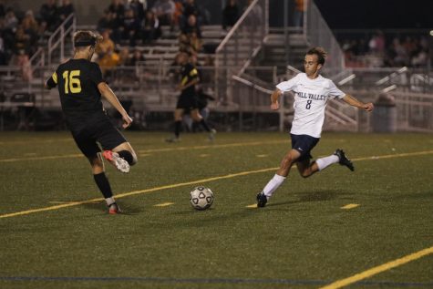 Senior Jack Gilmore runs to the ball to kick it before his opponent does.