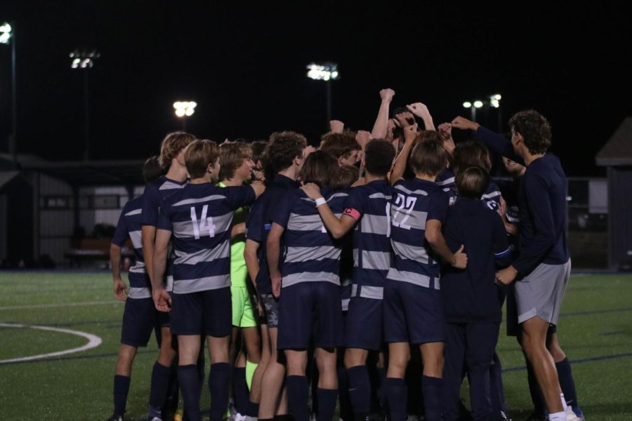 After defeating Shawnee Mission East, the team gathers for a huddle.