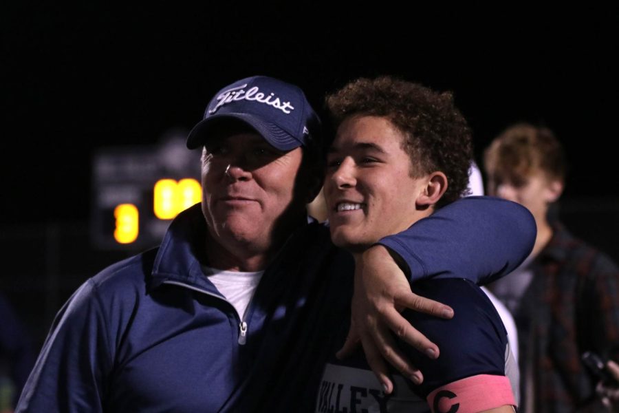 Celebrating the win, senior Luke Shideler stands for a picture with a family member.