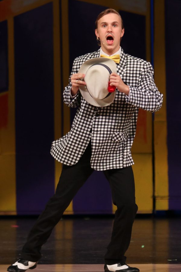 Hat in his hands, senior Carter Harvey dances on stage while playing the role of Nathan Detroit. 