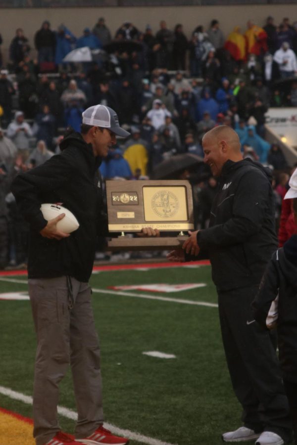 Head coach Joel Applebee is handed the state trophy after the Jags won 28-14.