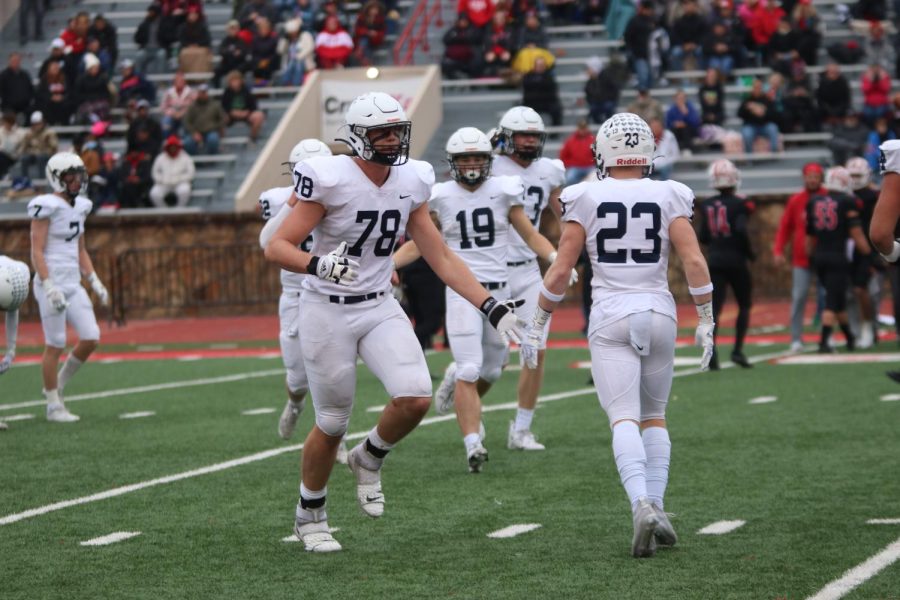 Junior Gus Hawkins high fives his teammate, Senior Holden Zigmant.