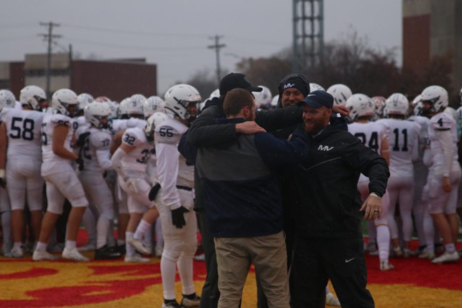 After an emotional win, the defensive coaches exhange hugs.