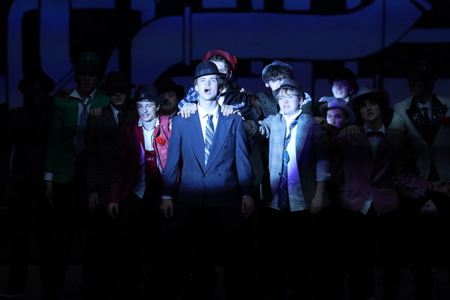 In the middle of the stage, senior Finn Campbell, who plays Sky Masterson, sings with the rest of the cast.