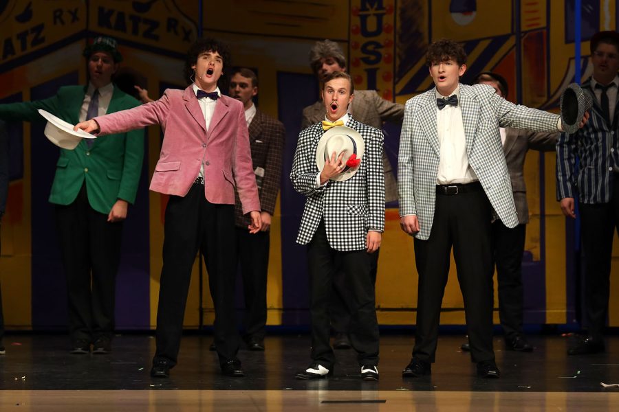 With their hats in their hands, seniors Brayden Heath, Carter Harvey and sophomore Blake Gray stand in the center of the stage. 