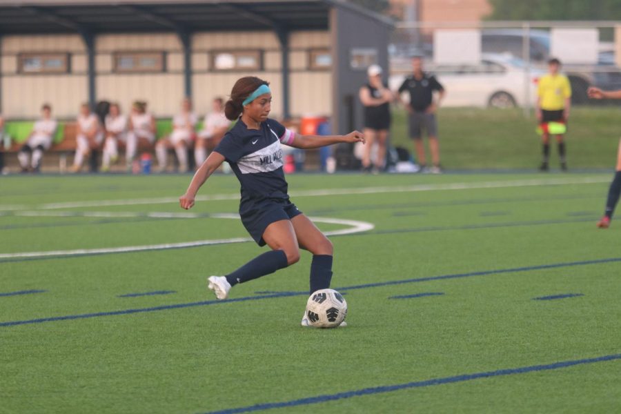 With possession of the ball, senior Acacia Weis dribbles down midfield Thursday, May 12. 