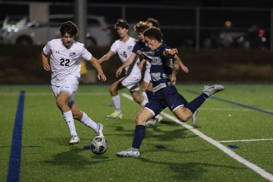 In the middle of the field, senior Luke Shideler prepares to kick the ball. 
