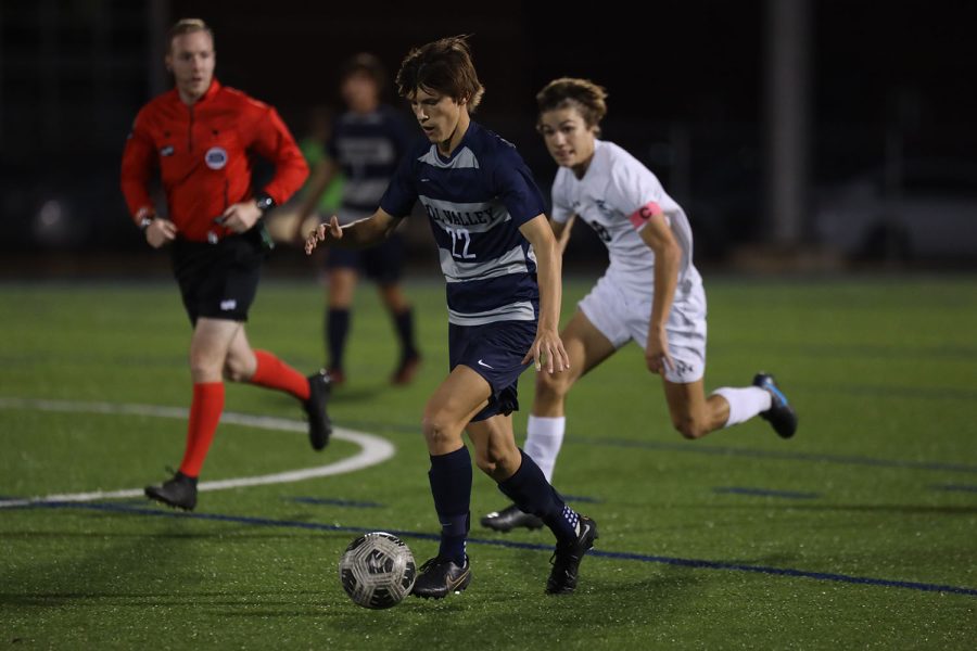 With a defender behind him, sophomore Brady Robins dribbles the ball. 
