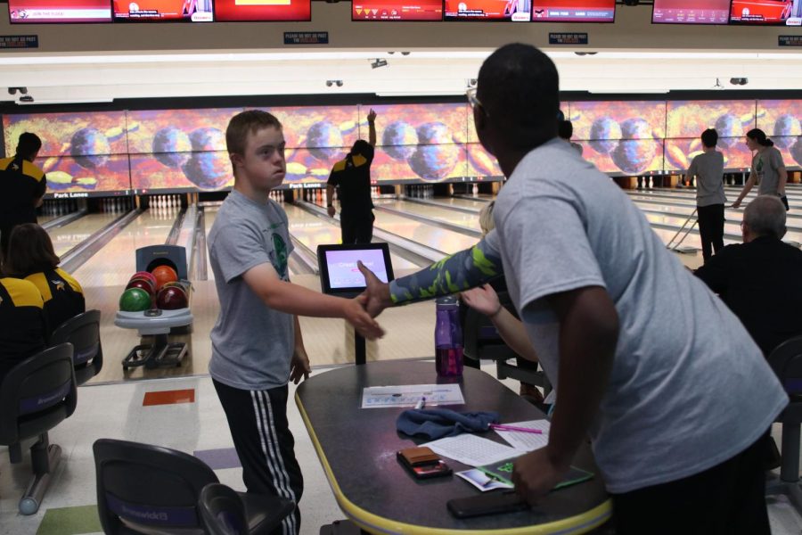 Junior Tucker Tibbits high fives senior Chase Neville after bowling a strike.