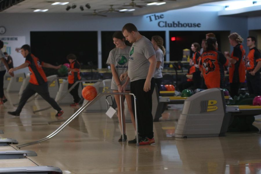 Senior Jane McDaneld and junior Gus Gosch watch as the ball rolls down the ball ramp.