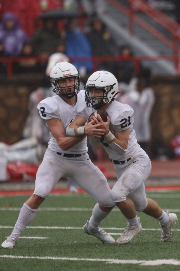 Senior quarterback Hayden Jay hands the ball off to junior running back Tristan Baker.