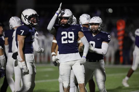 After an exciting play, senior Dylan Massey holds up his fin toward the crowd. 