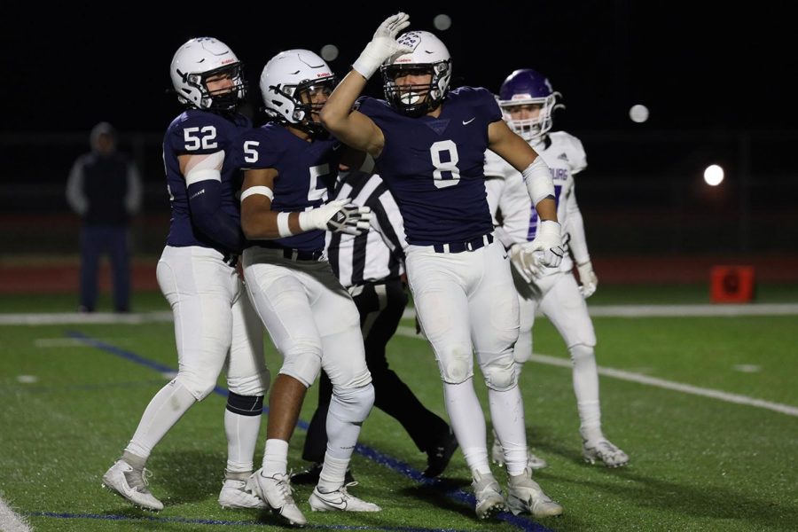 Celebrating his previous play, junior Truman Griffith holds up his landshark fin. 