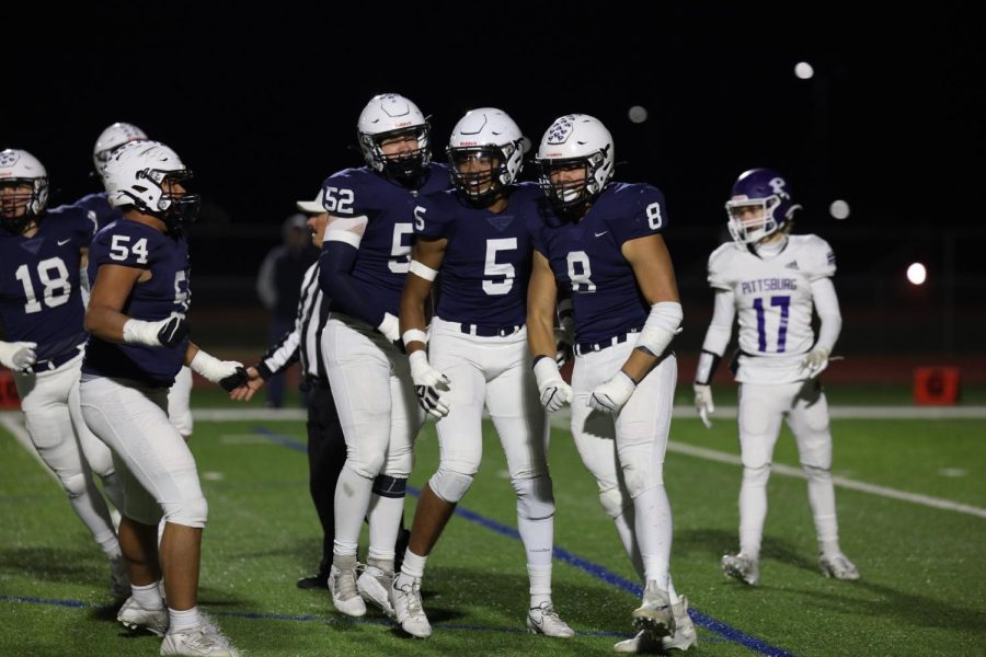 Excited from the previous play, junior Truman Griffith celebrates with sophomore Jayden Woods and senior Grant Rutkowski beside him. 