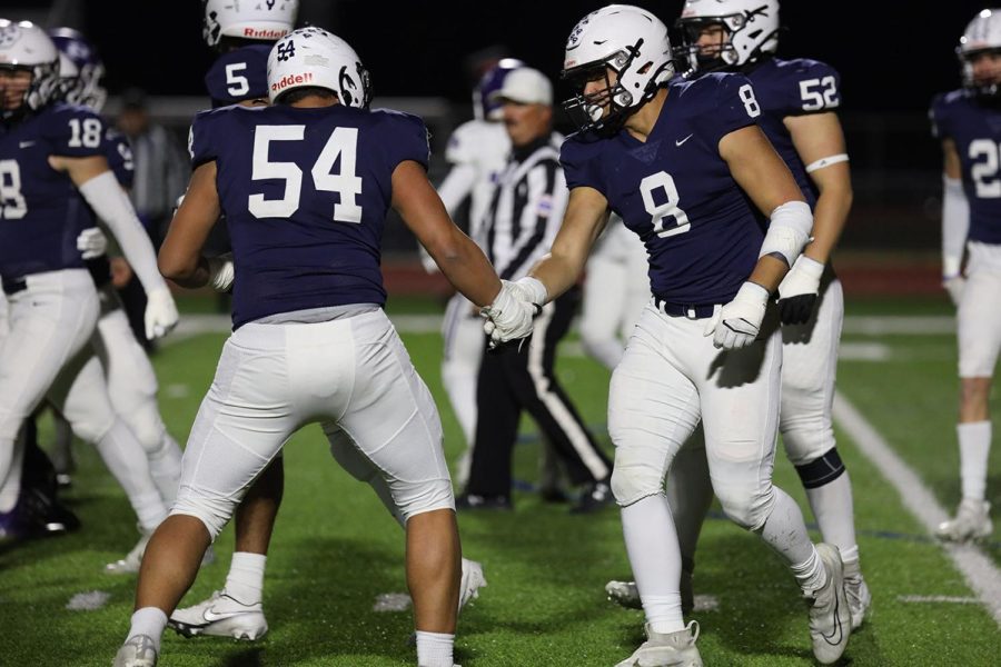 Congratulating his teammate, junior Truman Griffith shakes hands with senior Spencer Vaka.