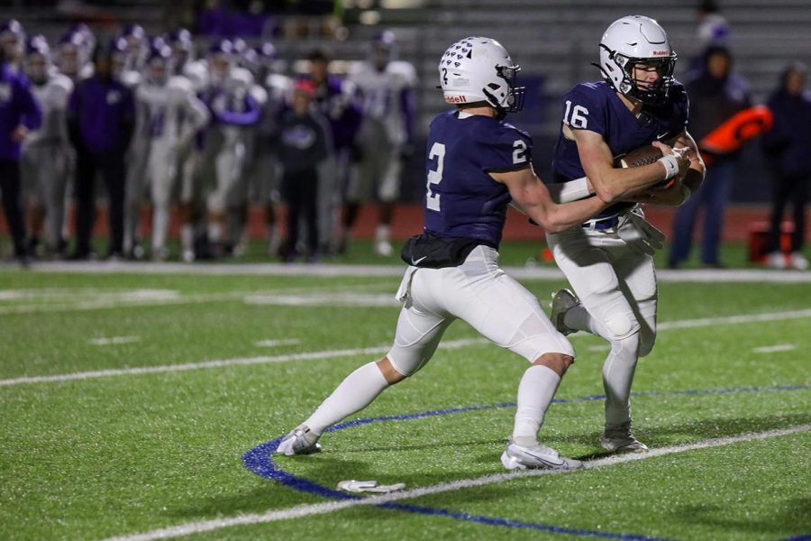 Taking the ball from senior quarterback Hayden Jay, sophomore Connor Bohon gets ready to run down the field. 