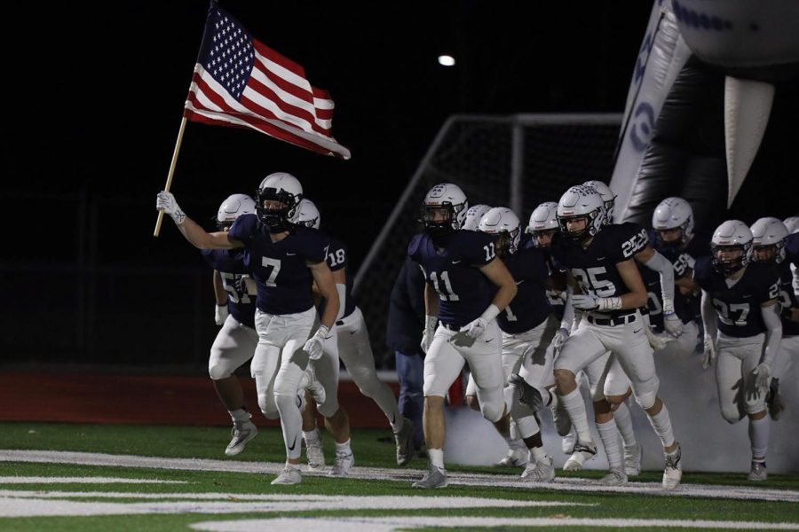 Running out of the tunnel, senior Mikey Bergeron leads fellow teammates onto the field to begin the game. 