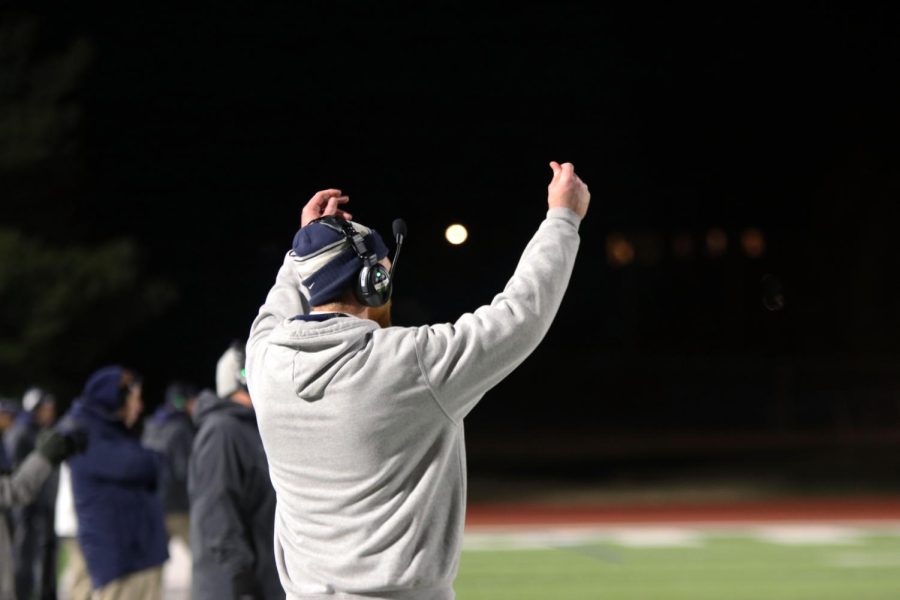 Coach Andrew Hudgins gives a sign to the defensive. 