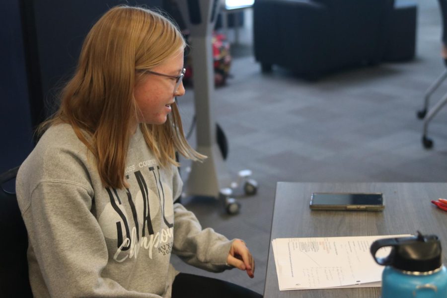 Situated at a desk, sophomore Laura Hickman focuses on completing English homework.