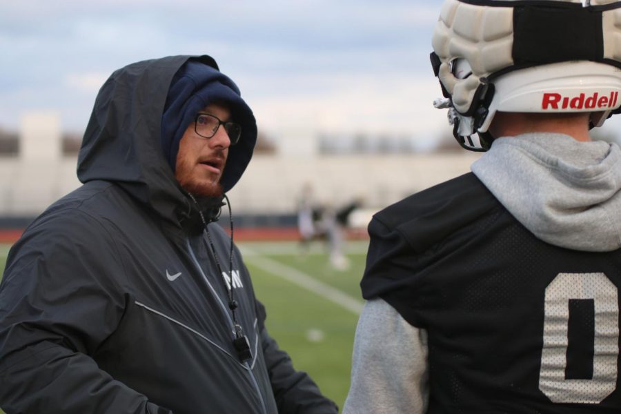 Talking to a player, coach Dustin Ester shows him what went wrong on a practice play.