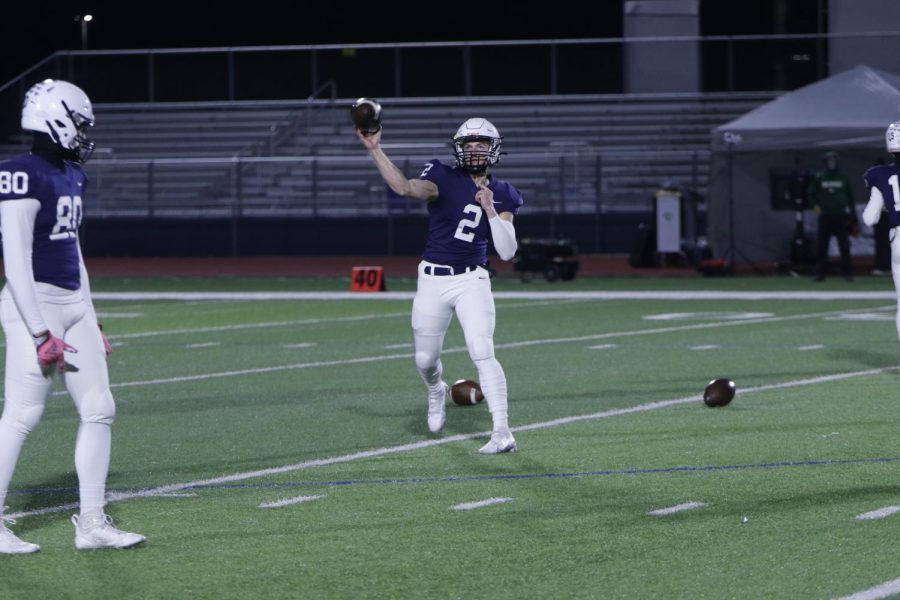 Warming up his arm, senior Haden Jay throws to a receiver.