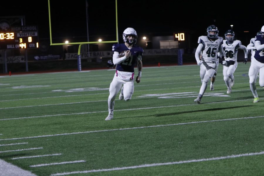 Scoring on the first play of the game, junior Tristan Baker slides through the defense.