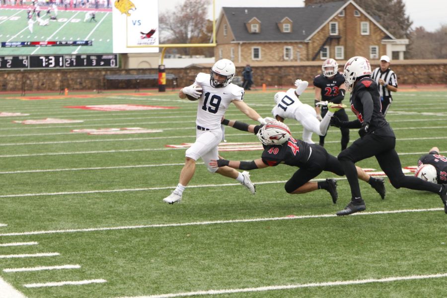 Giving a stiff arm to a defender, senior Hayes Miller fights for more yardage. 