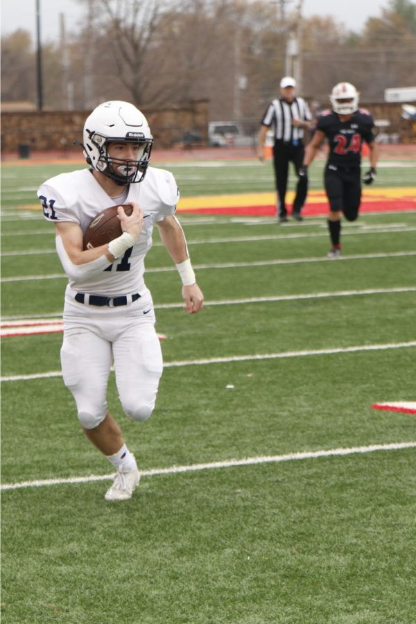 Sneaking past the defenders, junior Tristan Baker runs toward the endzone.