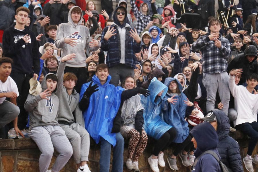 Holding up four fingers to represent the state title streak, the student section poses for a picture.