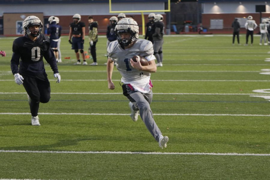 Running into the endzone, junior Tristian Baker slides past defenders.