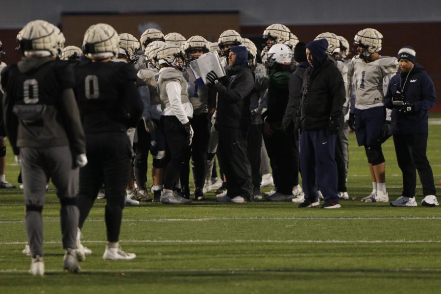 Leading the offense in play calling, coach Joel Applebee holds up the play book at practice Tuesday, Nov. 15.
