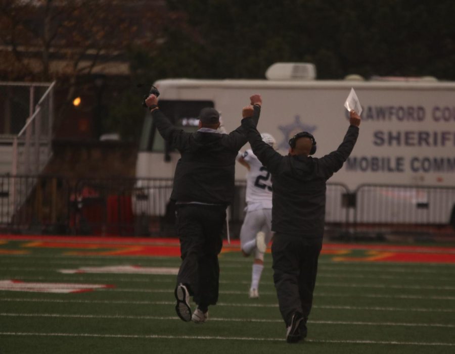Head coach Joel Applebee and defensive coordinator Drew Hughins hold their hands up in celebration at the conclusion of the game.
