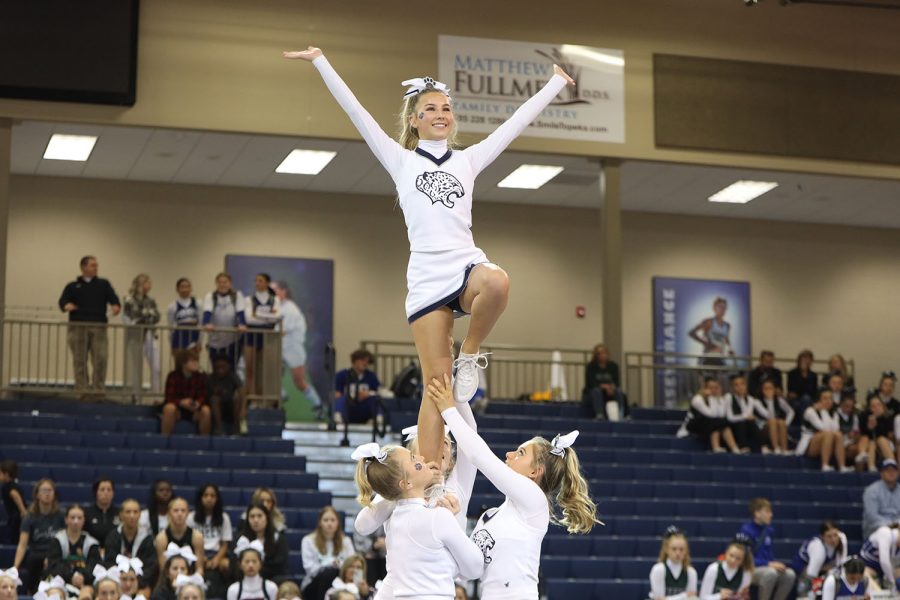 Smiling and waving to the crowd, freshman Sydney Epperson does a lib.