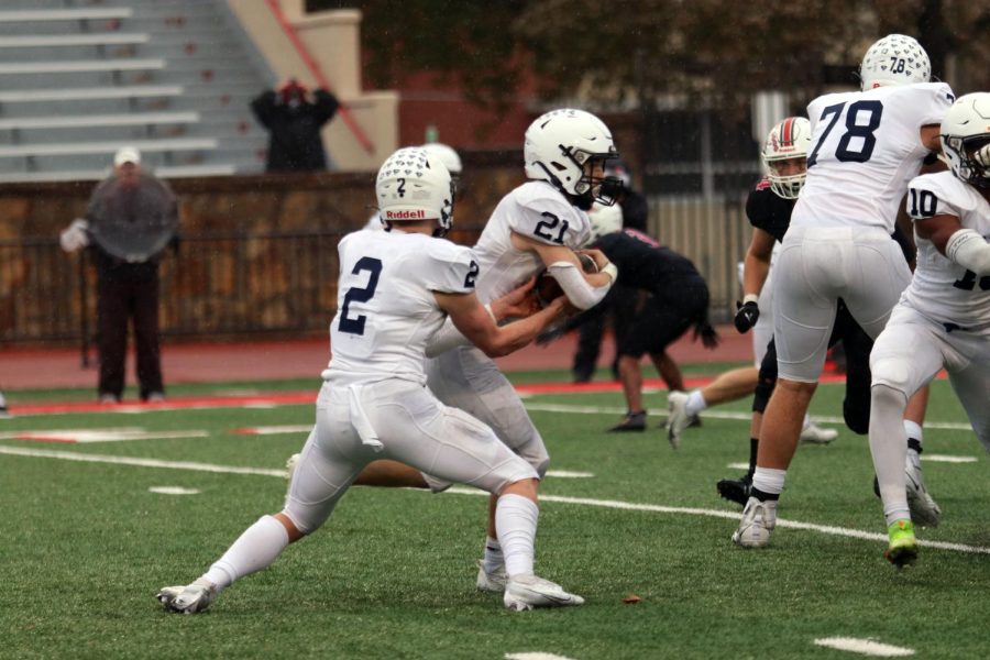 Senior Hayden Jay hands the ball to junior Tristan Baker. 