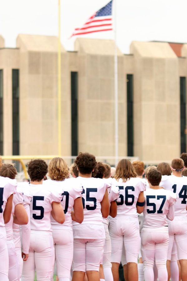 The team stands for the flag before the game starts.