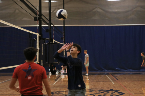 Senior Lucas Robins hits the volleyball over the net.