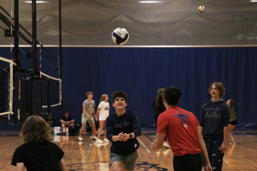 With his team watching, senior Lucas Robins goes up for the pass over the net.