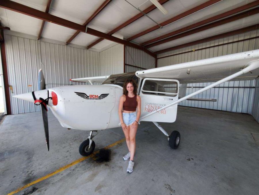 Senior Maya Parks, who is studying to become a commercial pilot, stands next to a plane that she has been learning to fly with. She has been practicing for a little over a year.
