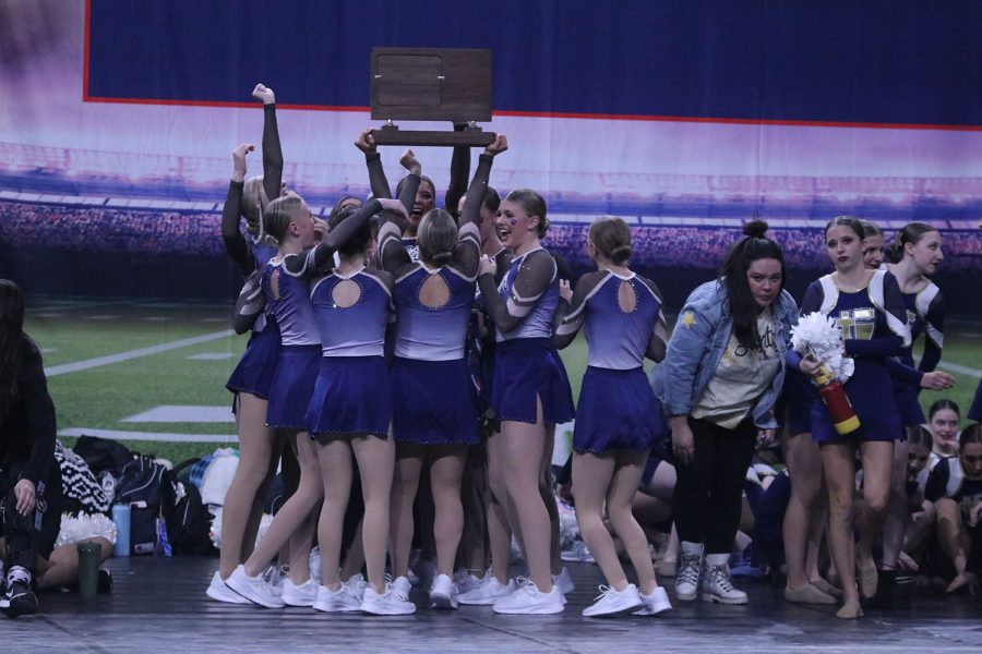 Thrusting the trophy in the air, the team celebrates the reward for all of their hard work. 
