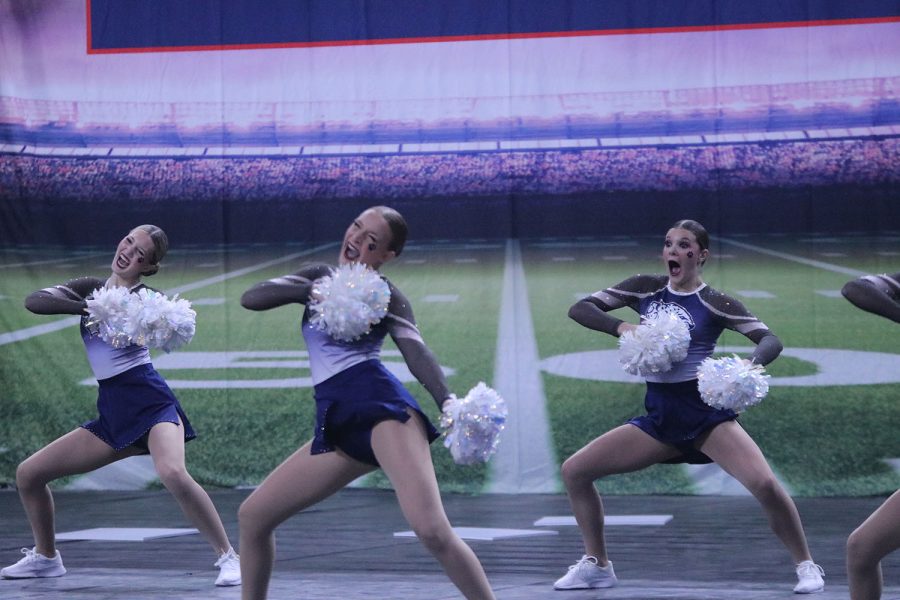 In sync, sophomores Chloe Lancaster and Ashley Ayers and freshman Savannah Seymour perform in front of the lights. 

