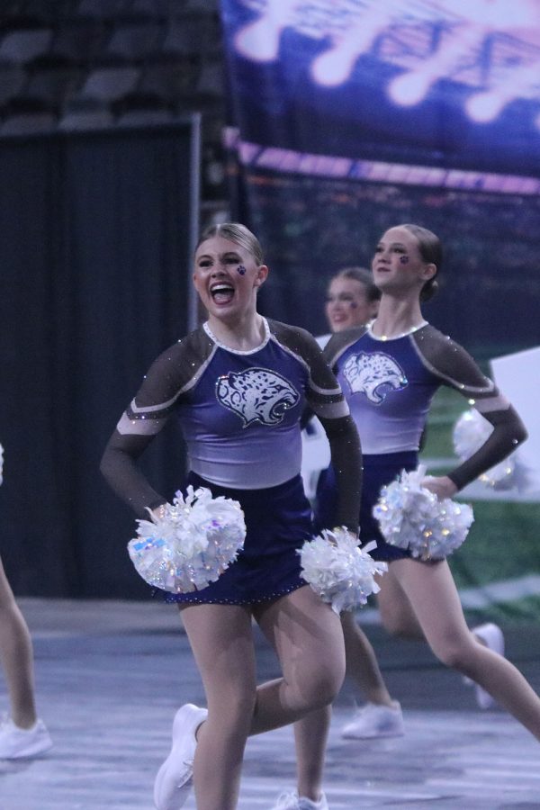 Moving across the floor, junior Halle Wampler smiles as she performs her third routine of the day. 
