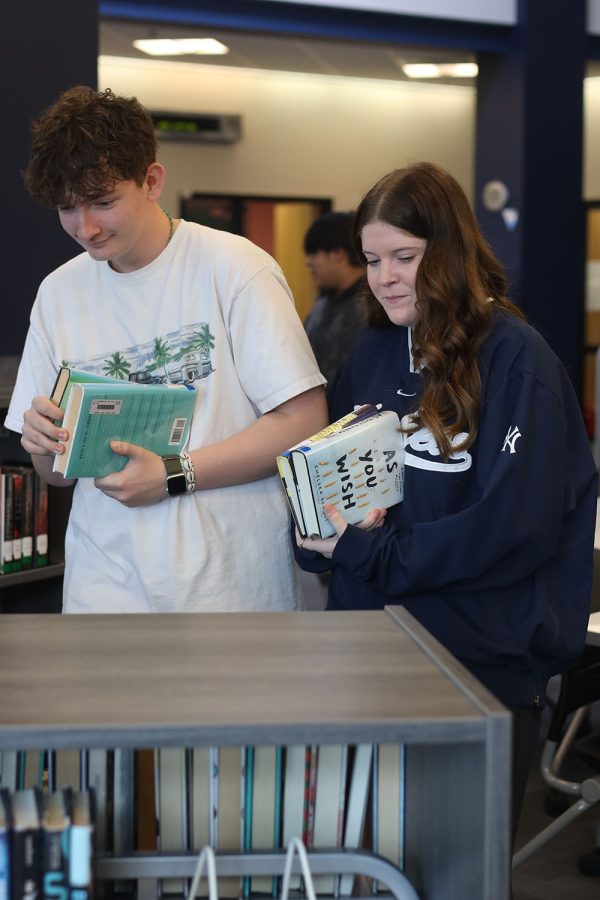 Sophomores Blake Gray and Hannah Weis pick books off of the shelf. 