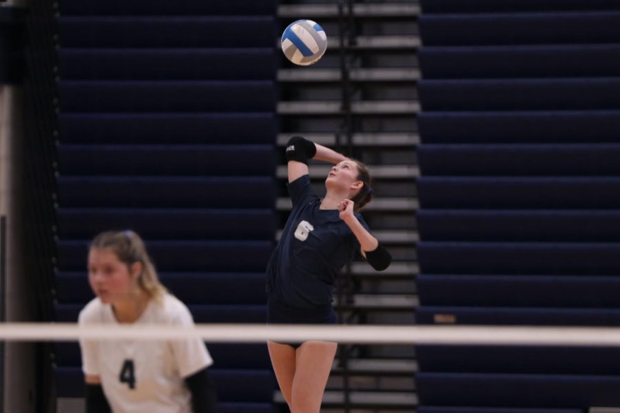 Serving the ball, junior Kaitlyn Burke throws the ball in mid air, winning against Olathe East and heading to state. Volleyball took fourth place at their first 6A state tournament Saturday, Oct. 29.