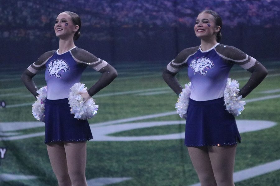 Standing up straight, junior Alli Gervais and sophomore Josie Mason perform with a smile on their face. 
