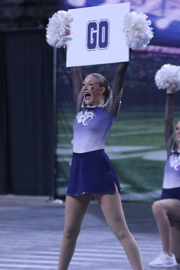 Holding up a sign in the fight song part of their finals routine, sophomore Ashley Ayers grins from ear to ear. 
