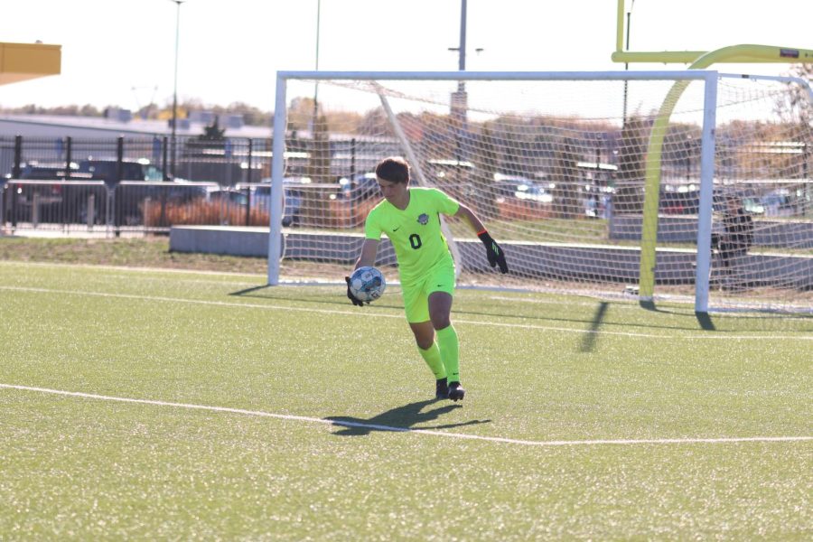 Tossing up the ball, senior Colin Riley prepares to kick the ball from the goal box.